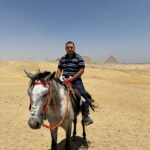 Tourist on horseback riding near the Pyramids of Giza in Cairo, Egypt