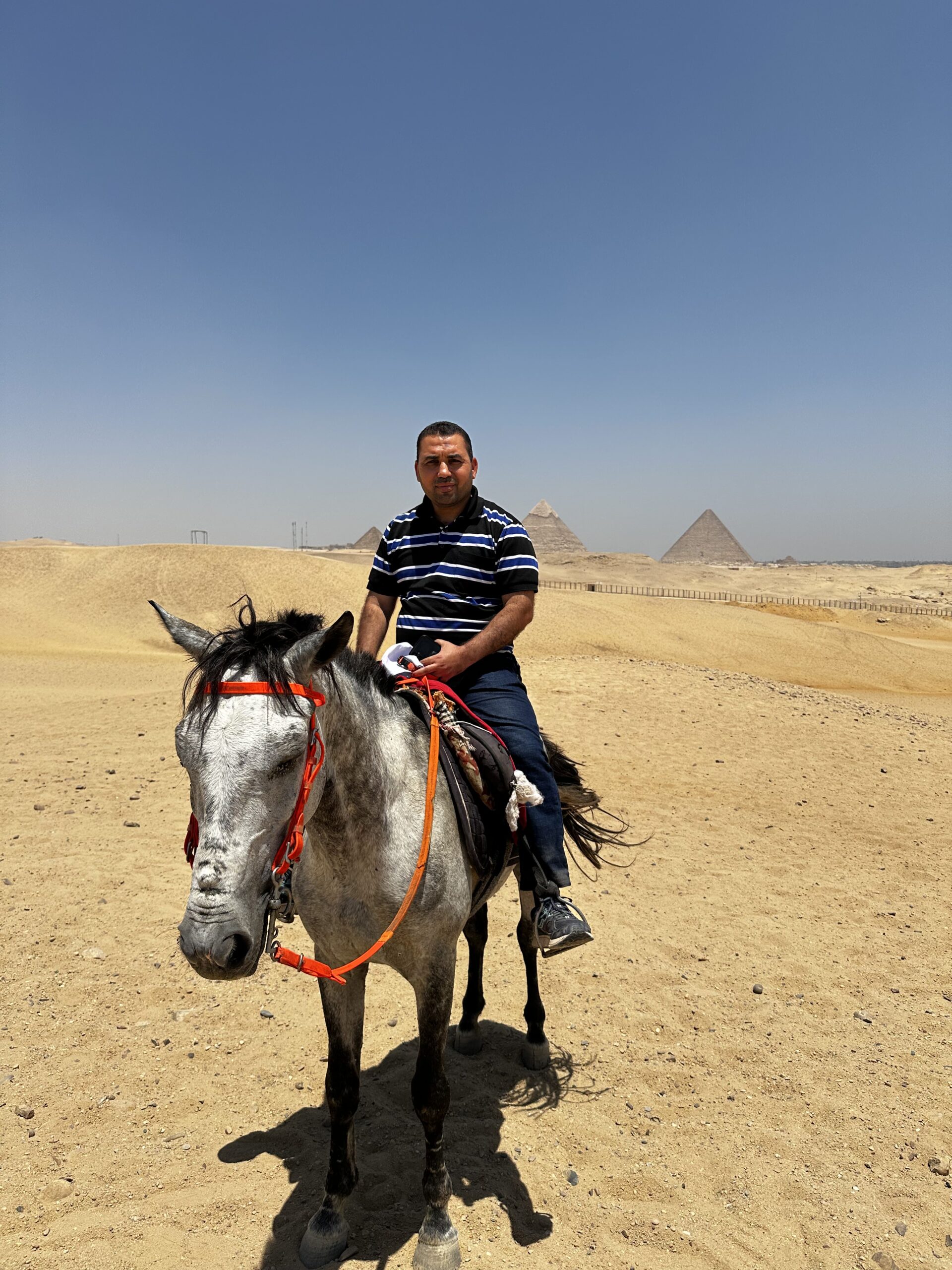 Tourist on horseback riding near the Pyramids of Giza in Cairo, Egypt